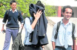 A student of Class XII covers his face while coming out of an examination centre in Chandigarh on Wednesday. His examination apparently did not go well.