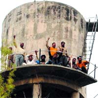 Daily-wagers of the Water Supply and Sanitation Department on top of a water tank in Amritsar on Wednesday