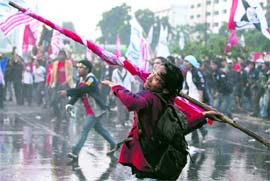 A protester throws a pole towards the police during a rally by students outside Parliament in Jakarta. Indonesias Parliament looks set to recommend a criminal investigation of two top reformers in President Susilo Bambang Yudhoyonos cabinet over their role in a bank rescue, party sources said on Wednesday