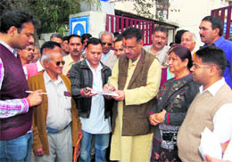 Ruling BJP workers conduct a signature campaign against rising prices of essential commodities in Dehradun on Thursday. 