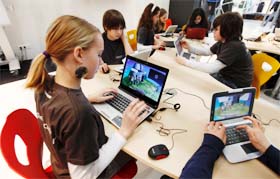 Pupils of Berlin's Hausburg European school use laptops with a new children-friendly Microsoft software at the world's largest IT fair, CeBITs exhibition centre in Hanover