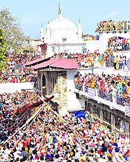 Devotees raise the Jhanda Sahib at the Jhanda Mela at Guru Ram Rai Darbar Sahib in Dehradun on Friday.