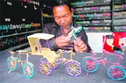 A toy-maker busy making bicycles from aluminium wires in Katra market. 