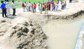 People surround the pit where four children accidentally fell and died on Friday night in Gopalpur village (Timarpur) on Saturday.