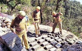 Officials of the Forest Department break bricks at an illegal mining site in Mussoorie on Saturday