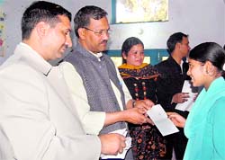Uttarakhand Agriculture Minister Trivendra Singh Rawat gives away scholarship cheques to students of Laxmi Devi Academy at Shivpuri in Dehradun on Saturday