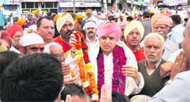 Mahant Devinder Dass of Guru Ram Rai Darbar acknowledges the greetings of devotees during the annual nagar parikarma.