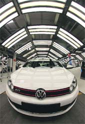 An employee makes a final check on the bodywork of Volkswagen Golf car during a photocall in a production line at the Volkswagen headquarters in Wolfsburg.