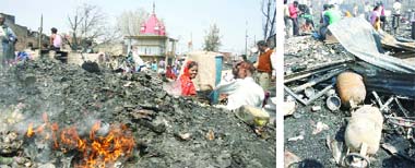 People sitting around the debris where nearly 350 jhuggis caught fire at Sadar Bazaar area in old Delhi early in the morning