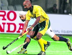 Indians Sandeep Singh fight for the ball with South Africa's Julian Hykes during the Hero Honda FIH World Cup Hockey tournament 2010 at Major Dhayanchand National stadium in New Delh on Monday