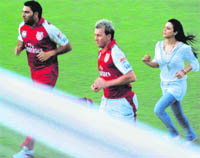 Bollywood actor and co-owner of the Kings XI Punjab Preity Zinta jogs with Yuvraj Singh and Brett Lee at the PCA Stadium in Mohali