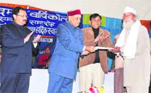 Chief Minister Prem Kumar Dhumal honours Gopal Dass Shyamu at the annual function of the HP State Journalists Federation in Bilaspur.