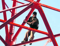 An agitator climbs down a Parsar Bharati tower in Dehradun on Wednesday