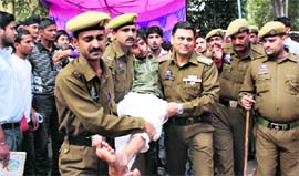 Police personnel take a striking student to the GMCH in Jammu on Wednesday