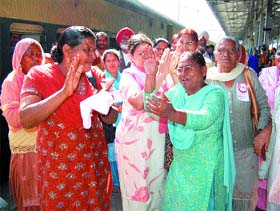 Women members of the Communist Party of India celebrate the passing of the Womens Reservation Bill in the Rajya Sabha, at Amritsar railway station. 
