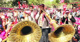 Workers of Left parties blowing traditional bugles during a protest march against price rise in New Delhi
