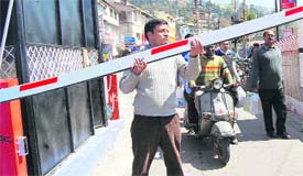 A Nagar Palika employee operates the computerised barrier manually at Library Bazar.