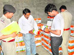 The police and the health authorities check stocks of ghee on the premises of a dealer in Fatehabad. 