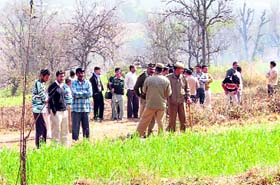 People and policemen looking for a leopard which had sneaked into Laharda village recently