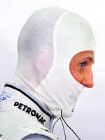 Mercedes Formula One driver Michael Schumacher wears his balaclava at the pits before the third practice session of the Bahrain F1 Grand Prix at Sakhir circuit in Manama