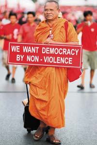 A Buddhist monk holds a banner as he joins other supporters of former premier Thaksin Shinawatra in central Bangkok