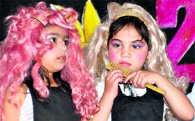 Young girls wear wigs to perform at a cultural programme at their school in Dehradun on Monday.