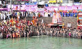 Saints perform puja at Har-ki-Pauri in Haridwar on Monday.