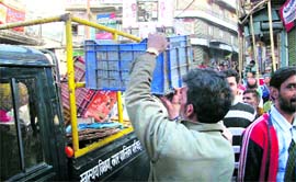 A palika employee confiscates the goods from encroachers during an anti-encroachment drive in Mussoorie on Monday.