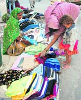A woman sells old clothes for poor near Committee Chowk in Karnal.