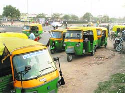 Autorickshaws parked haphazardly on the road in front of the Inter-State Bus