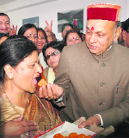 Chief Minister PK Dhumal offers sweets to Vimla Kashyap who will become the first BJP woman leader to make it to Parliament after filing nomination papers for the Rajya Sabha seat at Shimla on Tuesday.