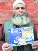 Abdul Ahad Mir with his picture receiving the Best Farmers award.
