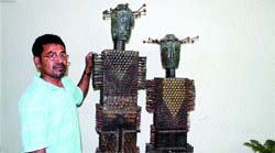 Basudeb Biswas poses with one of his artworks in Jalandhar.