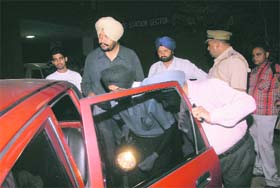 Police officials examine the car, the occupant of which was fired upon, in Sector 11, Chandigarh