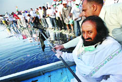 Spiritual guru Sri Sri Ravi Shankar cleans the Yamuna during the Meri Dilli Meri Yamuna campaign in New Delhi