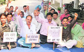 Non-teaching staff of Arya College hold protest in Ludhiana on Thursday.
