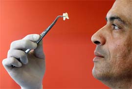 Professor Imad About, researcher of Marseilles faculty of orthodontics, poses as he examines a human tooth in his laboratory in Marseille, France.