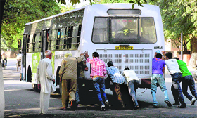 Passengers push a CTU bus at Sector 29 in Chandigarh on Friday. The CTU has decided to hike its fares, but the upkeep of buses leaves much to be desired.