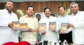 Chief Minister Ramesh Pokhriyal Nishank releases coffee table book Life and Time along with Opposition leaders in Dehradun on Friday.