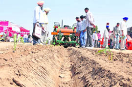 Himanshu Mahajan Farmers examine the new machine on display at Kisan Mela.