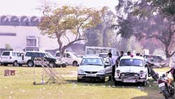 Vehicles parked in the middle of the football ground at the PAU, Ludhiana, on Saturday. Tribune photo: Himanshu Mahajan