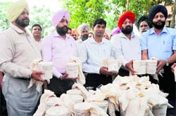 Officials from the special narcotics cell of the state police with sacks containing 26 kg of seized heroin during a press conference in Amritsar on Sunday.  AFP