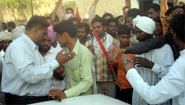 Revenue officials surrounded by NREGA workers at Khuyiansarwar BDPO office.