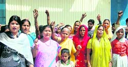 Women from the Kuanwala-Harrawala region protest in front of Jal Sansthan Awum Nirman Nigam office in Dehradun on Monday. A Tribune photograph