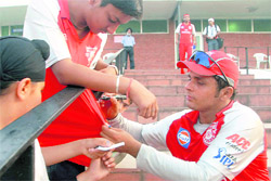 Painting the town red: Former India all rounder and Kings XI player Reetinder Sodhi signs autographs at the Sector 16 stadium in Chandigarh on Tuesday.