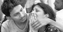 A man tries to console the relative of a fire tragedy victim at SSKM hospital in Kolkata on Wednesday.