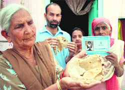 Beneficiaries of the below poverty line atta dal scheme show a chappati made from the poor quality flour provided to them at Bassi Pathana.