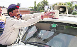 A policeman removes a red beacon atop a car as part of a campaign launched by the police in Dehradun on Thursday.