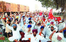Farmers raise slogans in favour of their demands at Attari on Friday