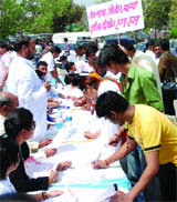 People take part in a public signature campaign against price hike organised by the Delhi Pradesh Bharatiya Janata Party at Palika Bazar, Connaught Place in New Delhi 